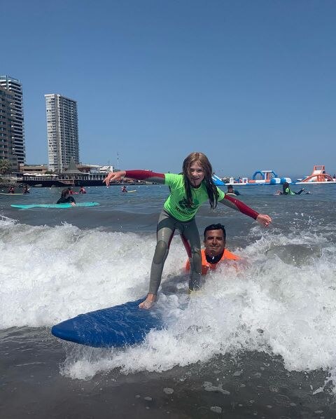 joven aprendiendo a surfear en playa cavancha ciudad de iquique chile