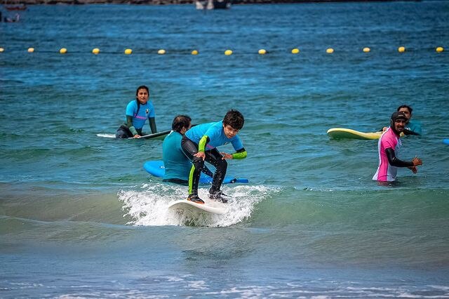 jovenes surfeando en playa cavancha en la ciudad de quique