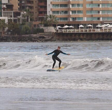 mujer surfeando en la ciudad de iquique