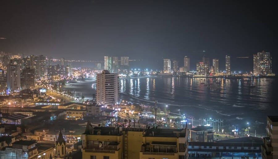 En la imagen se muestra la ciudad de Iquique de noche, específicamente playa Cavancha, la playa más popular de Iquique